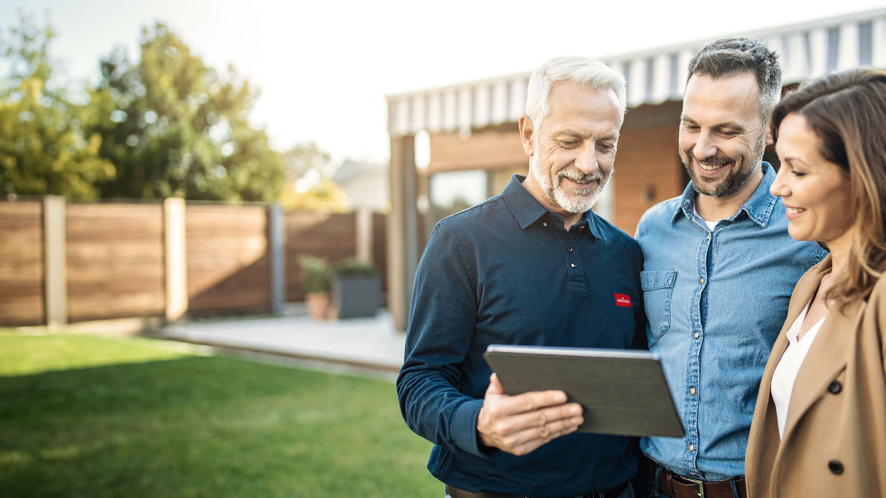 weinor Fachpartner berät ein Kundenpaar am Tablet unter einem Terrassendach